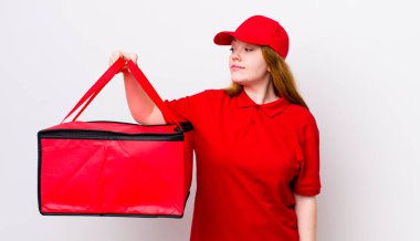 Profil bakışlı kızıl saçlı güzel kadın hayal mi kuruyor yoksa hayal mi kuruyor? Pizza teslimatı kavramı