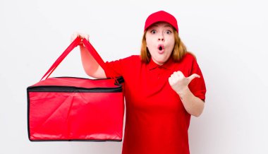 Kızıl saçlı, güzel bir kadın inançsızlıktan şaşkın şaşkın bakıyor. Pizza teslimatı kavramı