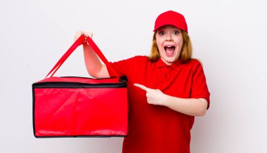 Kızıl saçlı, güzel bir kadın heyecanlı ve şaşırmış görünüyor. Pizza teslimatı kavramı