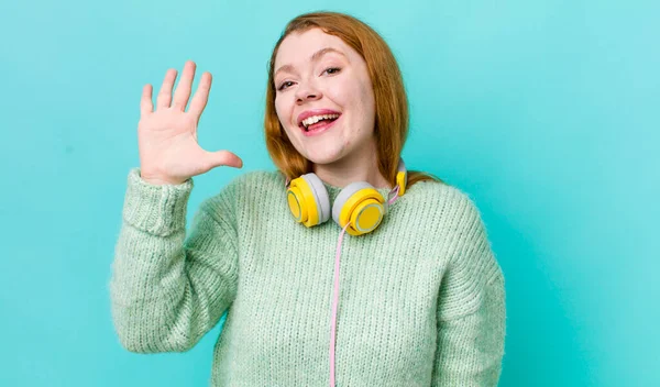 Rote Kopf Hübsche Frau Lächelt Und Sieht Freundlich Zeigt Nummer — Stockfoto