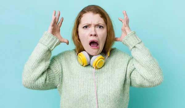 Kızıl saçlı güzel kadın ellerini havaya kaldırarak çığlık atıyor. Müzik konseptinin tadını