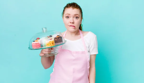 赤の頭の可愛い女は困惑して混乱してる 家で作るケーキのコンセプト — ストック写真