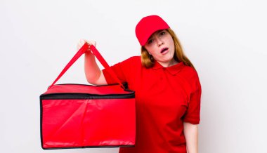 Kızıl saçlı güzel kadın şaşkın ve şaşkın hissediyor. Pizza teslimatı kavramı