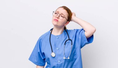 Kızıl saçlı güzel kadın şaşkın ve kafası karışık, kaşınan bir kafa hissediyor. hemşire konsepti