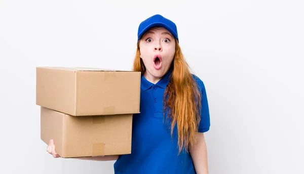 赤の頭のきれいな女性は非常にショックを受けているか驚いた 配送ボックスのコンセプト — ストック写真
