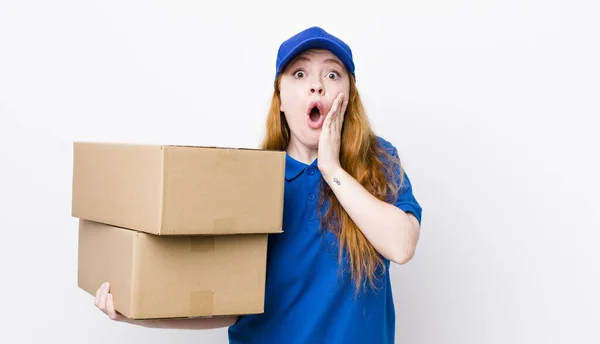 赤い頭の可愛い女はショックを受けて怖がってた 配送ボックスのコンセプト — ストック写真