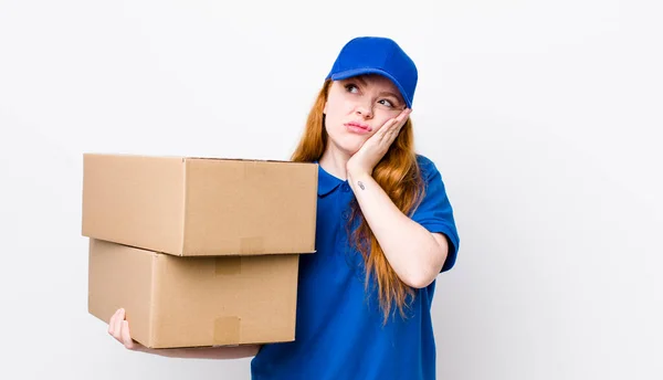 赤い頭のかなりの女性は退屈し フラストレーションと眠くなって疲れ後に感じている 配送ボックスのコンセプト — ストック写真