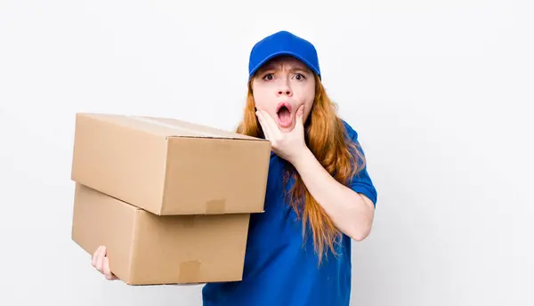 口と目の広い赤い頭のきれいな女性が開いて顎に手を 配送ボックスのコンセプト — ストック写真