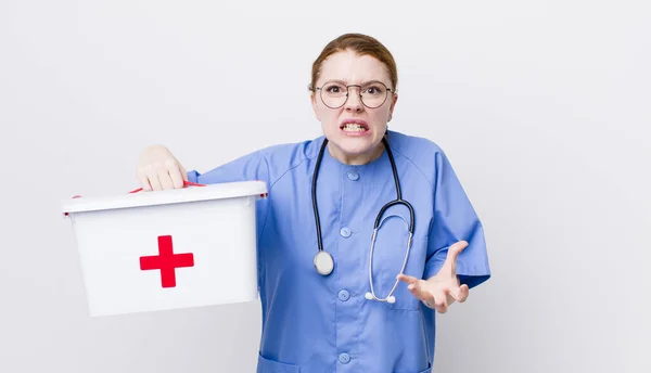 赤の頭の可愛い女は怒っていらいらしていらいらしてる 看護師の概念 — ストック写真