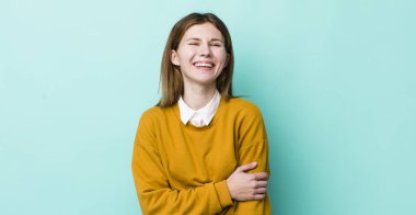 kızıl saçlı güzel kadın utangaç ve neşeli bir şekilde gülüyor, arkadaş canlısı ve olumlu ama güvensiz bir tavırla.