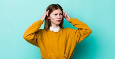 Kızıl saçlı, güzel bir kadın kafası karışık ya da şüpheci, bir fikre odaklanmış, çok düşünüyor, kenarda boşluğu kopyalamak istiyor.