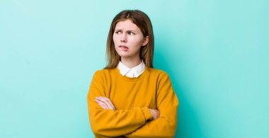 Kızıl saçlı, kuşkulanan ya da düşünen, dudağını ısıran, kendine güveni olmayan ve gergin hisseden, kenarda yer arayan güzel bir kadın.