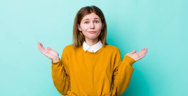 Kızıl saçlı güzel kadın şaşkın ve kafası karışık, şüpheci, farklı seçenekleri tartıyor ya da komik ifadeli seçiyor.