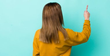 Kızıl saçlı güzel kadın dikiz aynasında duran ve objeyi işaret eden