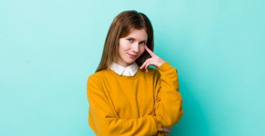 Kızıl saçlı güzel kadın sana göz kulak oluyor, güvenmiyor, izliyor, tetikte ve tetikte.