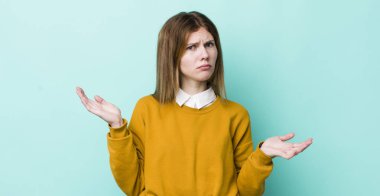 Şaşkın, kafası karışmış ve stresli görünen kızıl saçlı güzel bir kadın. Farklı seçenekler arasında merak ediyor. Belirsiz hissediyor.