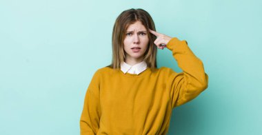 Kızıl saçlı güzel bir kadın kafası karışık ve şaşkın hissediyor. Deli, deli ya da aklını kaçırmış olduğunu gösteriyor.