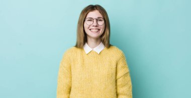 Kızıl saçlı güzel kadın mutlu ve şapşal görünüyor. Geniş, eğlenceli, kaçık bir gülüşü ve açık gözleri var.