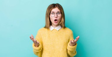 Kızıl saçlı güzel bir kadın ağzı açık ve şaşkın, şok olmuş ve hayretler içinde inanılmaz bir sürprizle