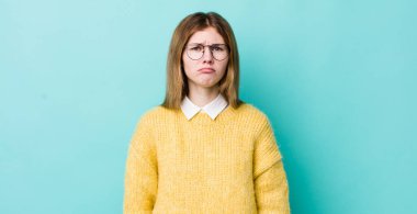 Kızıl saçlı, güzel bir kadın üzgün ve mızmız, mutsuz bir bakışla ağlıyor, olumsuz ve hayal kırıklığına uğramış bir tavırla.