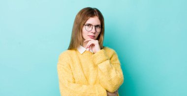 Kızıl saçlı güzel kadın ciddi görünüyor, kafası karışık, kararsız ve düşünceli, seçenekler ve seçenekler arasında şüpheci.