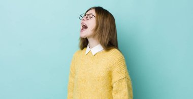 Kızıl saçlı güzel kadın öfkeyle bağırıyor, agresif bir şekilde bağırıyor, stresli ve kızgın görünüyor.