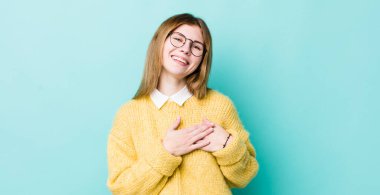 Kızıl saçlı güzel bir kadın romantik, mutlu ve aşık, neşeyle gülümseyen ve kalbe yakın el ele tutuşan