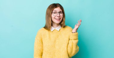 kızıl saçlı güzel bir kadın mutlu, şaşırmış ve neşeli, olumlu bir tavırla gülümseyen, bir çözüm ya da fikir gerçekleştiren.