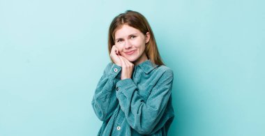 Kızıl saçlı güzel bir kadın aşık ve sevimli görünüyor. Sevimli ve mutlu. Romantik bir şekilde gülümsüyor.