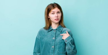 Kızıl saçlı güzel kadın şaşkın, şaşkın ve güvensiz hissediyor, kendini gösterip kim olduğunu soruyor, ben mi??