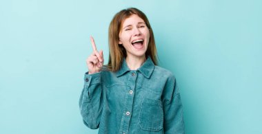 Kızıl saçlı, güzel bir kadın bir fikri fark ettikten sonra mutlu ve heyecanlı bir dahi gibi hissediyor. Neşeli bir şekilde parmağını kaldırıyor.!