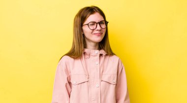 kızıl saçlı güzel bir kadın mutlu ve arkadaş canlısı görünüyor, gülümsüyor ve sana olumlu bir tavırla göz kırpıyor.