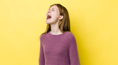 Kızıl saçlı güzel kadın öfkeyle bağırıyor, agresif bir şekilde bağırıyor, stresli ve kızgın görünüyor.