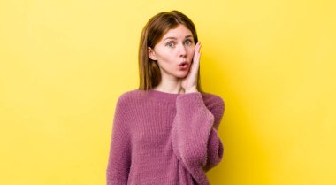 Kızıl saçlı, güzel bir kadın şoke olmuş ve ağzı açık bir şekilde yüz yüze inanamamaktan şaşkına dönmüş.