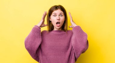 Kızıl saçlı, güzel bir kadın ellerini havaya kaldırıp bağırıyor. Öfkeli, sinirli, stresli ve üzgün.