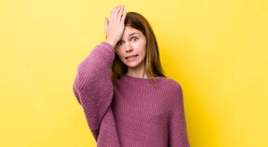 red head pretty woman raising palm to forehead thinking oops, after making a stupid mistake or remembering, feeling dumb