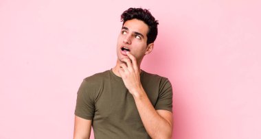 Şaşırmış, gergin, endişeli ya da korkmuş bakışları olan yakışıklı İspanyol bir adam kopya boşluğuna bakıyor.