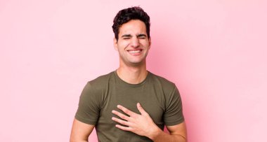 Yakışıklı İspanyol adam komik bir şakaya yüksek sesle gülüyor, mutlu ve neşeli hissediyor, eğleniyor.