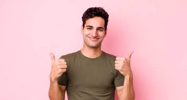 Yakışıklı İspanyol adam neşeyle gülümsüyor ve mutlu görünüyor, kaygısız ve pozitif hissediyor.