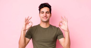 Yakışıklı İspanyol adam konsantre olmuş ve meditasyon yapıyor, tatmin olmuş ve rahatlamış hissediyor, düşünüyor ya da bir seçim yapıyor.