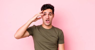 Yakışıklı İspanyol adam mutlu, şaşkın ve şaşırmış görünüyor, gülümsüyor ve inanılmaz ve inanılmaz iyi haberleri fark ediyor.