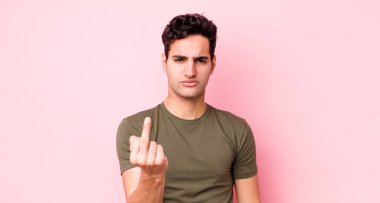 Yakışıklı İspanyol adam kızgın, sinirli, isyankar ve agresif orta parmağını sallayarak karşılık veriyor.
