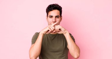 Yakışıklı İspanyol adam ciddi görünüyor ve iki parmağının önde olması hoşnutsuzca reddedilerek sessizlik istiyor.