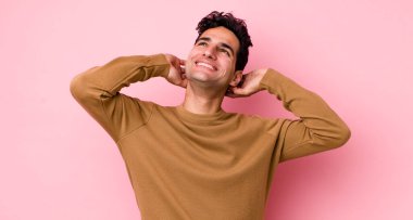 Yakışıklı İspanyol adam gülümsüyor ve rahatlıyor, tatmin oluyor ve kaygısızca gülüyor.