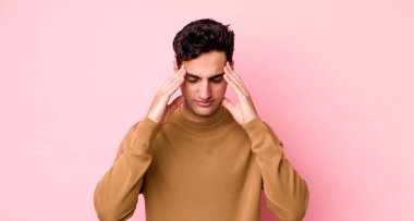 Yakışıklı İspanyol bir adam stresli ve hayal kırıklığına uğramış görünüyor, baskı altında çalışıyor ve başı ağrıyor.