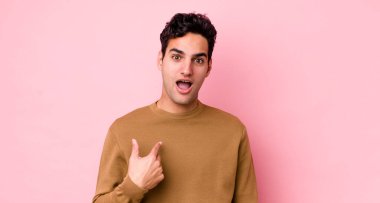 Yakışıklı İspanyol adam şok olmuş ve ağzı açık, kendini işaret ederek şaşırmış görünüyor.
