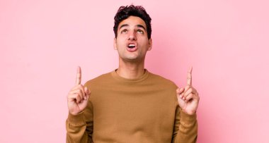 Yakışıklı İspanyol bir adam şaşırmış ve ağzı açık. Şok olmuş ve şaşırmış bir şekilde yukarı bakıyor.