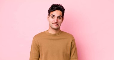 Yakışıklı İspanyol adam şaşkın ve şaşkın görünüyor. Sinirli bir hareketle dudağını ısırıyor. Sorunun cevabını bilmiyor.