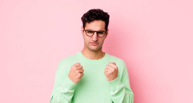 Yakışıklı İspanyol adam kendinden emin, sinirli, güçlü ve agresif görünüyor. Yumrukları boks pozisyonunda dövüşmeye hazır.