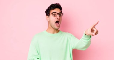 Yakışıklı İspanyol adam şaşkın ve şaşırmış hissediyor, şaşırmış ve hayranlıkla yukarı bakıyor, şaşkın, açık ağızlı bir bakışla